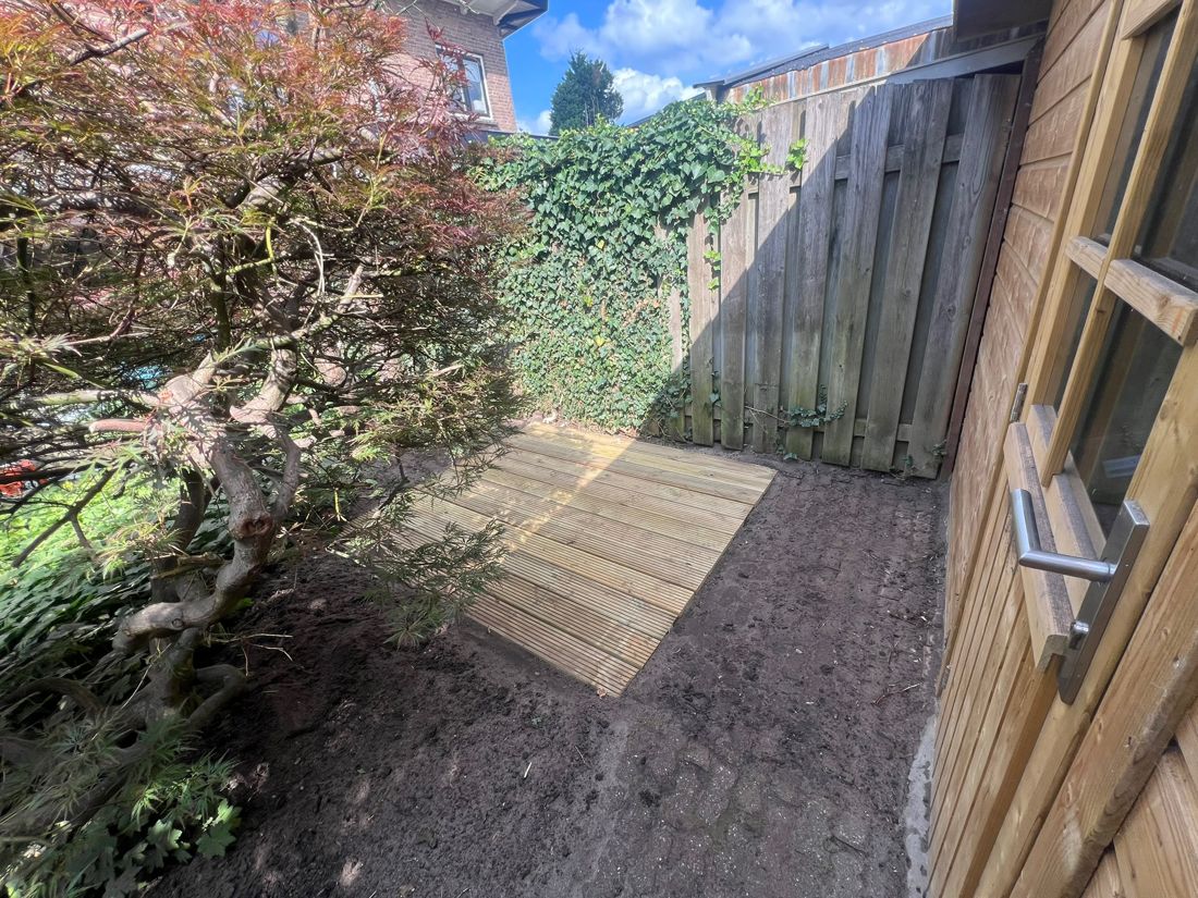Nieuwe houten vlonder naast het tuinhuis