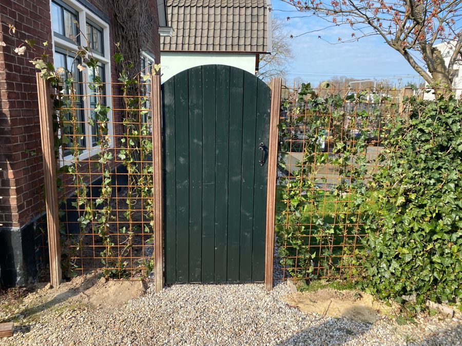 Nieuwe groene poort met cortenstalen gaas en jonge klimop